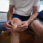 o persoană care se ține cu mâna de articulații și ligamentele din zona genunchiului pentru că nu și-a luat suplimentele necesare